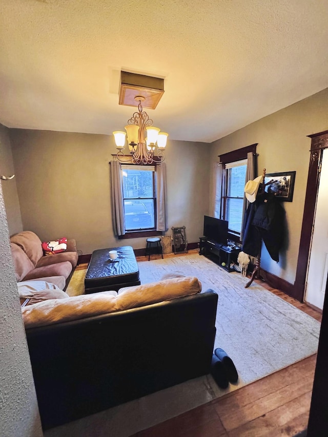 902 E Morgan St, Boonville, MO 65233 - living area featuring a chandelier, wood finished floors, and a textured ceiling
