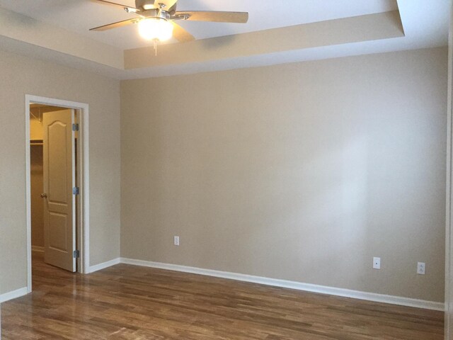 201 Port Way, Columbia, MO 65201 - empty room with wood finished floors, a ceiling fan, and a tray ceiling