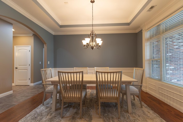 315 W Proctor St, Sturgeon, MO 65284 - dining room with wood finished floors, a chandelier, a raised ceiling, arched walkways, and crown molding