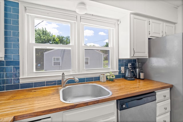 708 Clayton St, Columbia, MO 65203 - kitchen with stainless steel appliances, decorative backsplash, white cabinetry, and wood counters