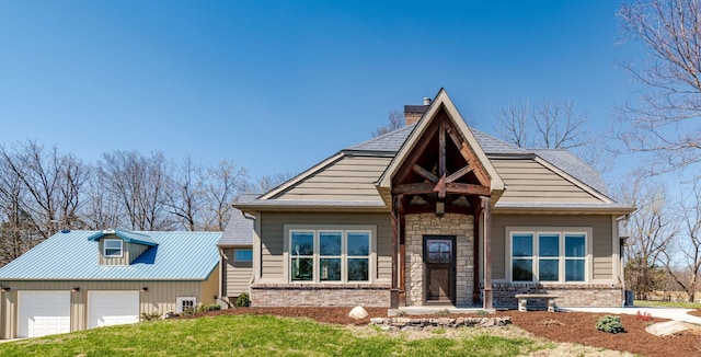 8900 W Graham Rd, Rocheport, MO 65279 - view of front of home featuring a garage, a front yard, brick siding, stone siding, and a chimney