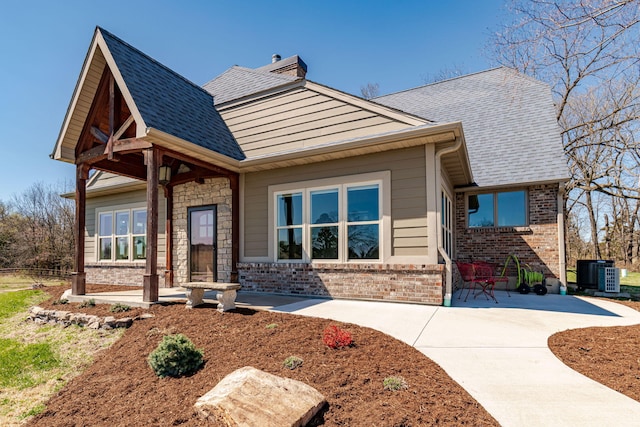 8900 W Graham Rd, Rocheport, MO 65279 - craftsman-style home with brick siding, a chimney, and a patio area