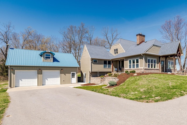 8900 W Graham Rd, Rocheport, MO 65279 - view of front of house with an outbuilding, a chimney, a detached garage, board and batten siding, and a front yard