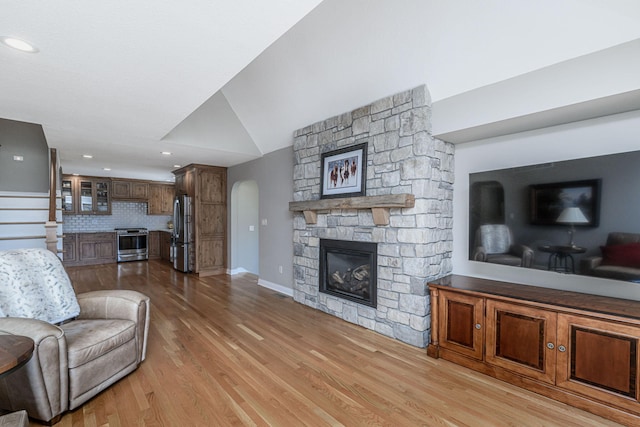 8900 W Graham Rd, Rocheport, MO 65279 - living area with arched walkways, light wood-style flooring, lofted ceiling, a fireplace, and recessed lighting