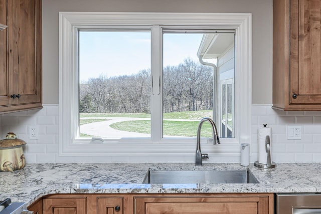 8900 W Graham Rd, Rocheport, MO 65279 - kitchen featuring brown cabinetry, decorative backsplash, and plenty of natural light