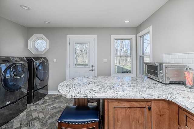 8900 W Graham Rd, Rocheport, MO 65279 - washroom with washing machine and clothes dryer, dark stone finish flooring, and recessed lighting