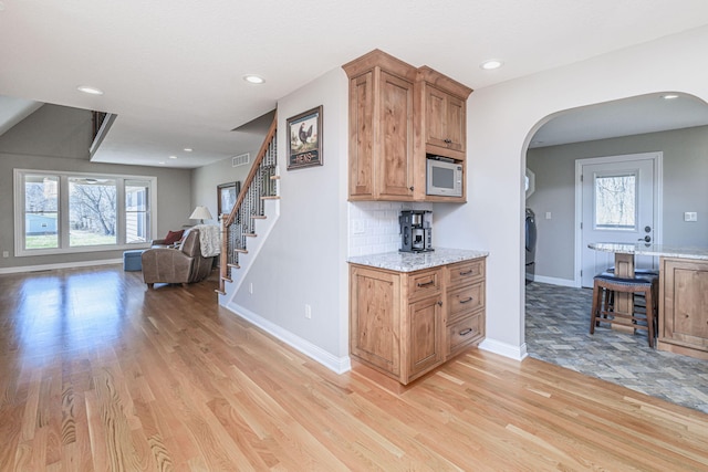 8900 W Graham Rd, Rocheport, MO 65279 - kitchen featuring arched walkways, white microwave, light wood-style floors, plenty of natural light, and recessed lighting