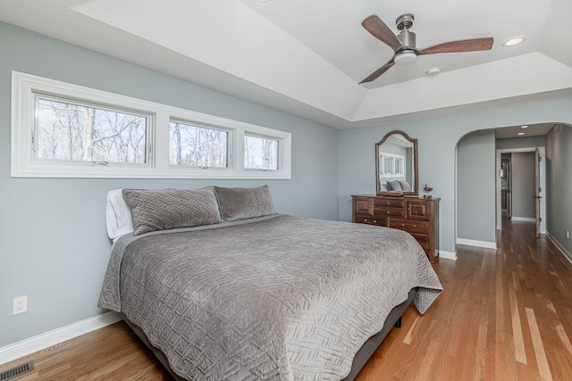 8900 W Graham Rd, Rocheport, MO 65279 - bedroom with wood finished floors, recessed lighting, a ceiling fan, a raised ceiling, and arched walkways