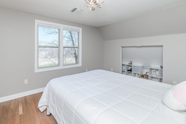 8900 W Graham Rd, Rocheport, MO 65279 - bedroom with wood finished floors, lofted ceiling, and a chandelier