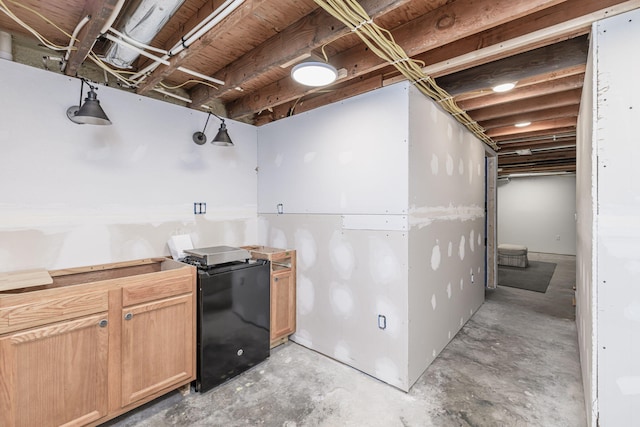 8900 W Graham Rd, Rocheport, MO 65279 - kitchen featuring unfinished concrete floors, light brown cabinets, and refrigerator