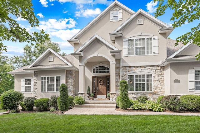 1707 Brookfield Mnr, Columbia, MO 65203 - view of front of property with stone siding, stucco siding, a front lawn, and a shingled roof