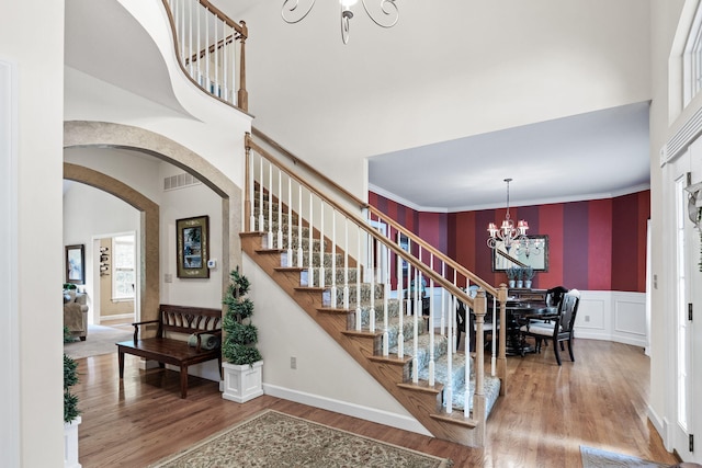 1707 Brookfield Mnr, Columbia, MO 65203 - stairs with a chandelier, a high ceiling, wood finished floors, arched walkways, and a decorative wall