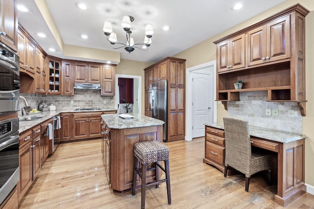 1707 Brookfield Mnr, Columbia, MO 65203 - kitchen featuring stainless steel appliances, open shelves, under cabinet range hood, light wood-type flooring, and backsplash