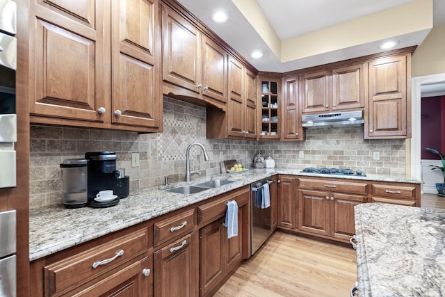 1707 Brookfield Mnr, Columbia, MO 65203 - kitchen with stainless steel dishwasher, under cabinet range hood, light stone counters, gas stovetop, and light wood-type flooring