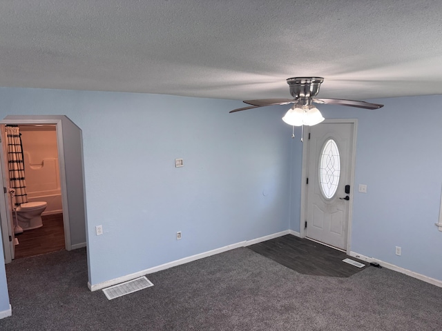 809 S 4th St, Moberly, MO 65259 - foyer entrance with ceiling fan, dark carpet, and a textured ceiling