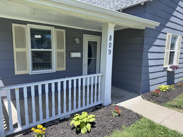 809 S 4th St, Moberly, MO 65259 - doorway to property featuring a porch and a shingled roof