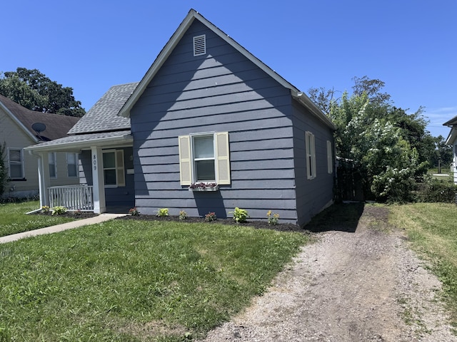 809 S 4th St, Moberly, MO 65259 - bungalow featuring a front yard, covered porch, and roof with shingles