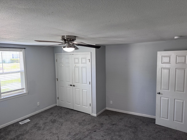 809 S 4th St, Moberly, MO 65259 - unfurnished bedroom with a closet, dark carpet, a textured ceiling, and ceiling fan
