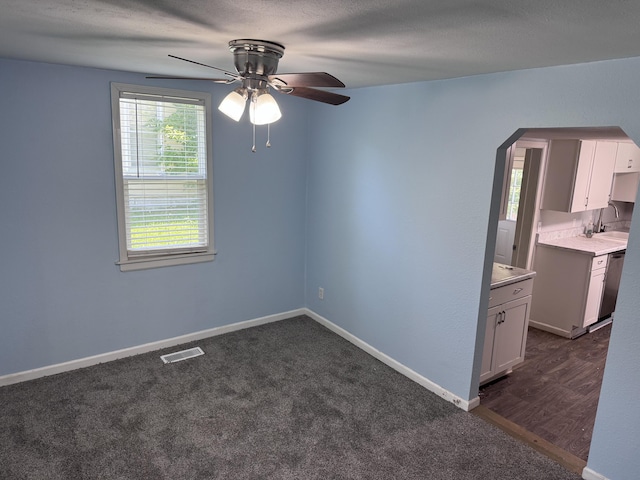 809 S 4th St, Moberly, MO 65259 - empty room with ceiling fan, arched walkways, and dark colored carpet