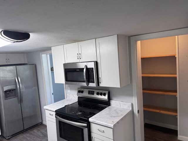 809 S 4th St, Moberly, MO 65259 - kitchen featuring appliances with stainless steel finishes, dark wood-type flooring, and white cabinetry
