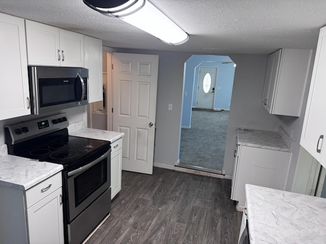 809 S 4th St, Moberly, MO 65259 - kitchen with stainless steel appliances, arched walkways, a textured ceiling, dark wood-style flooring, and white cabinets