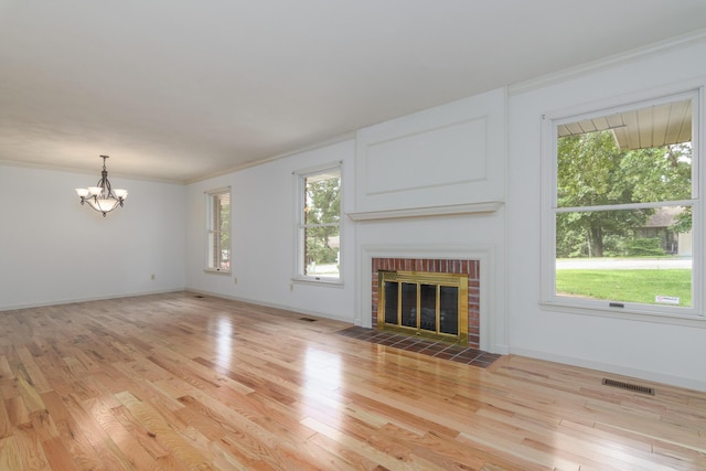 1745 Engelwood Dr, Jefferson City, MO 65101 - unfurnished living room with a chandelier, light wood-style flooring, a fireplace, and crown molding