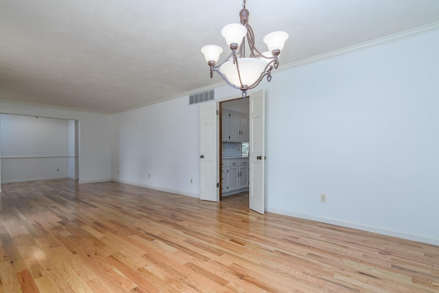 1745 Engelwood Dr, Jefferson City, MO 65101 - spare room featuring ornamental molding, a chandelier, and light wood-type flooring