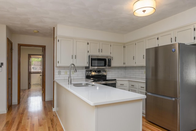 1745 Engelwood Dr, Jefferson City, MO 65101 - kitchen with stainless steel appliances, tasteful backsplash, light countertops, and light wood-type flooring