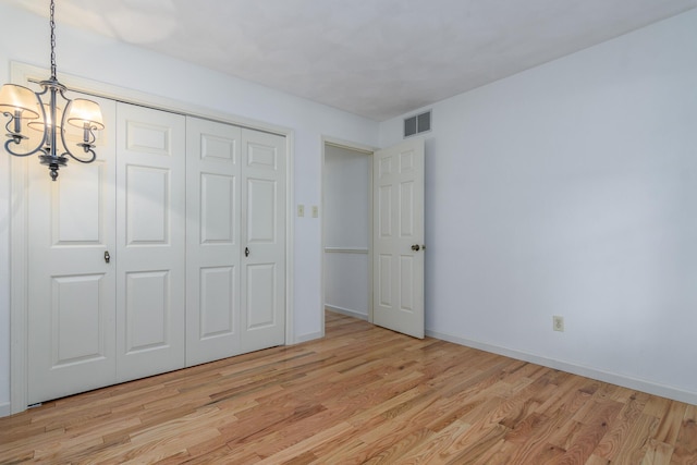 1745 Engelwood Dr, Jefferson City, MO 65101 - unfurnished bedroom with a chandelier, light wood finished floors, and a closet