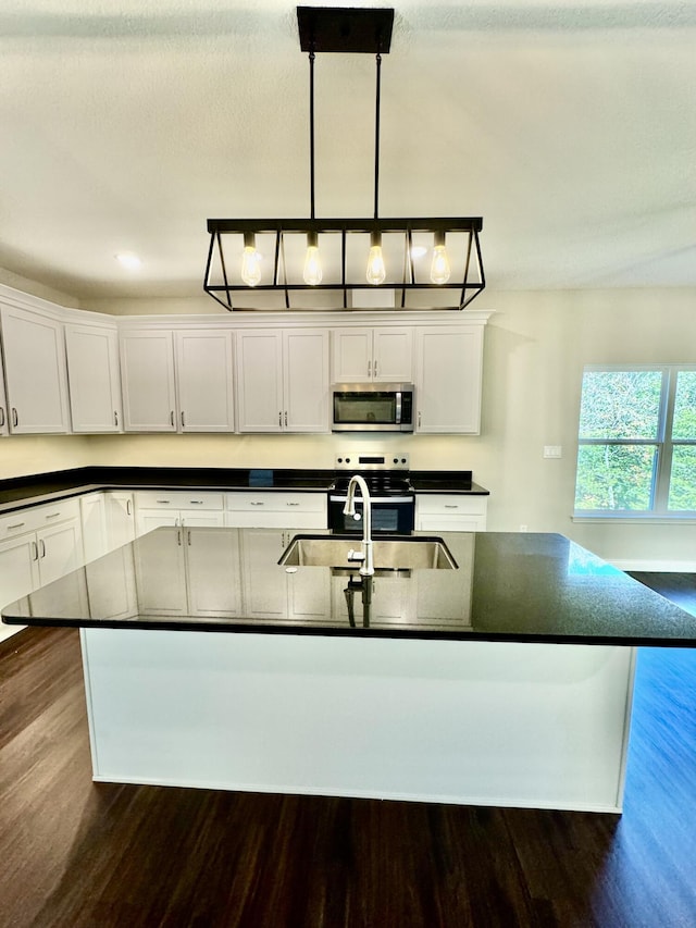 1680 W Fenton Rd, Columbia, MO 65202 - kitchen with appliances with stainless steel finishes, dark countertops, dark wood finished floors, and white cabinetry