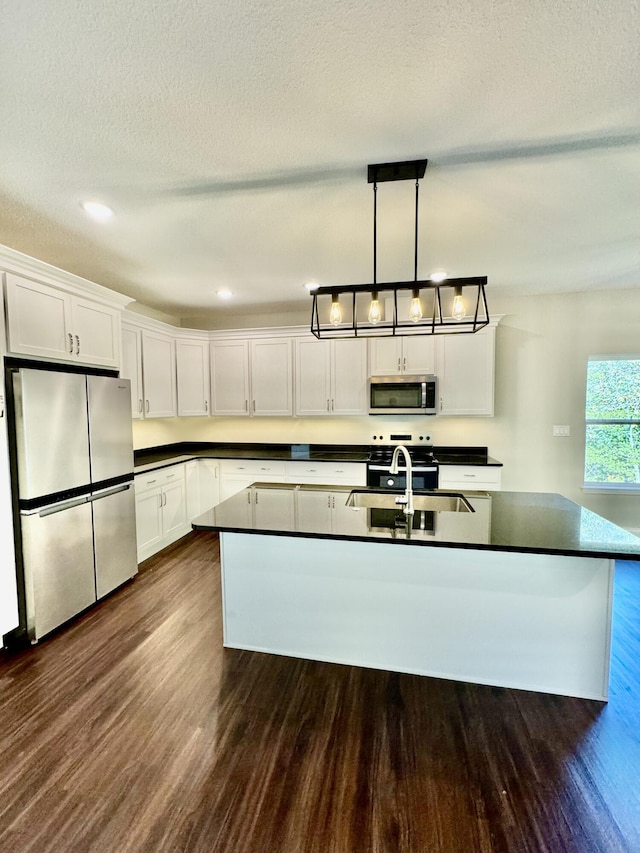 1680 W Fenton Rd, Columbia, MO 65202 - kitchen featuring appliances with stainless steel finishes, dark countertops, dark wood-style flooring, white cabinetry, and a textured ceiling