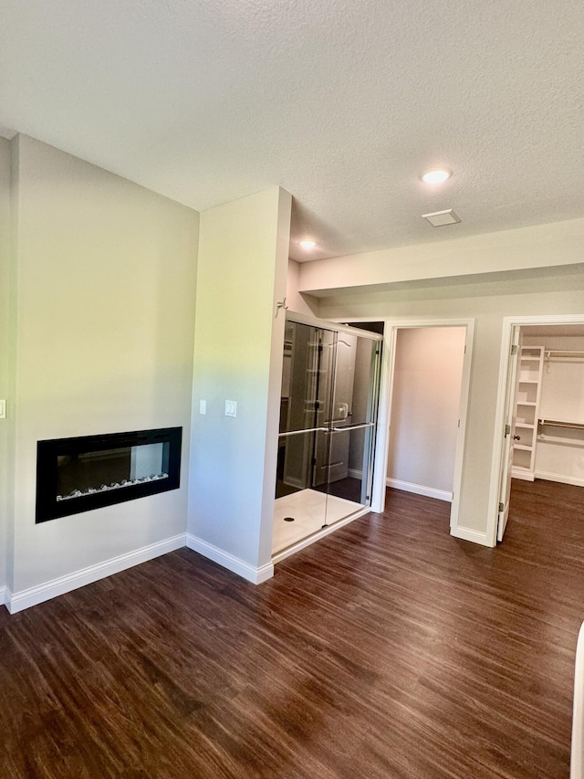 1680 W Fenton Rd, Columbia, MO 65202 - unfurnished bedroom with a glass covered fireplace, wood finished floors, recessed lighting, a textured ceiling, and a closet