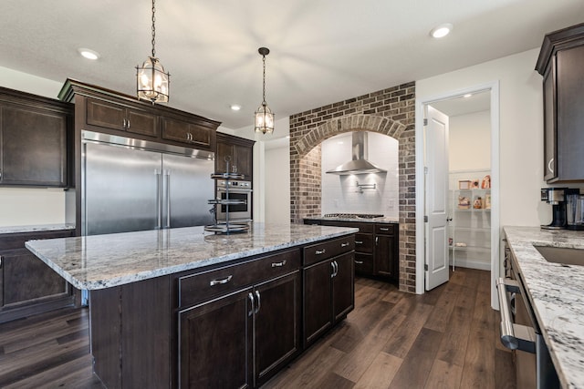 2821 Clopton Ct, Columbia, MO 65203 - kitchen with wall chimney range hood, appliances with stainless steel finishes, dark wood-style floors, dark brown cabinets, and recessed lighting