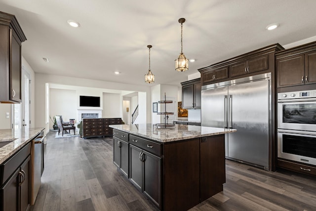 2821 Clopton Ct, Columbia, MO 65203 - kitchen with appliances with stainless steel finishes, dark brown cabinets, dark wood-style floors, a kitchen island, and recessed lighting