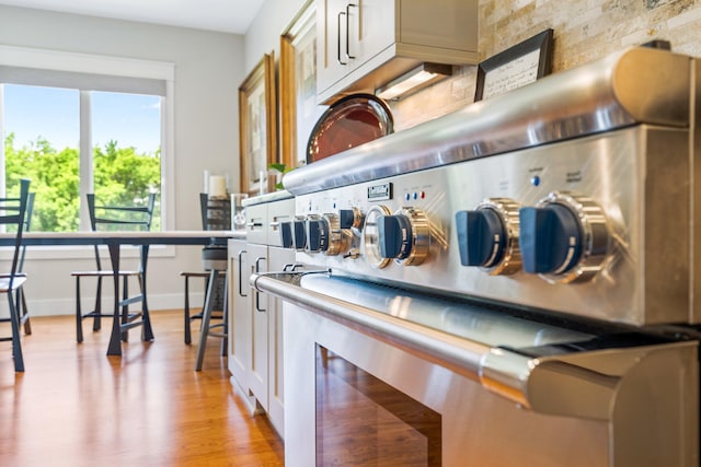 1107 Marcassin Dr, Columbia, MO 65201 - kitchen with range with two ovens, light wood-style flooring, and backsplash