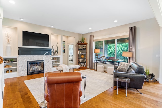 1107 Marcassin Dr, Columbia, MO 65201 - living area with wood finished floors, a glass covered fireplace, and recessed lighting