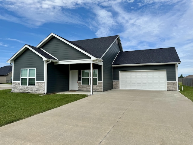 921 S Columbia St, Centralia, MO 65240 - view of front facade with stone siding, concrete driveway, an attached garage, and a front lawn