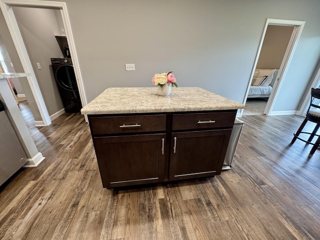 921 S Columbia St, Centralia, MO 65240 - kitchen with washer / clothes dryer, dark brown cabinetry, dark wood finished floors, and light countertops