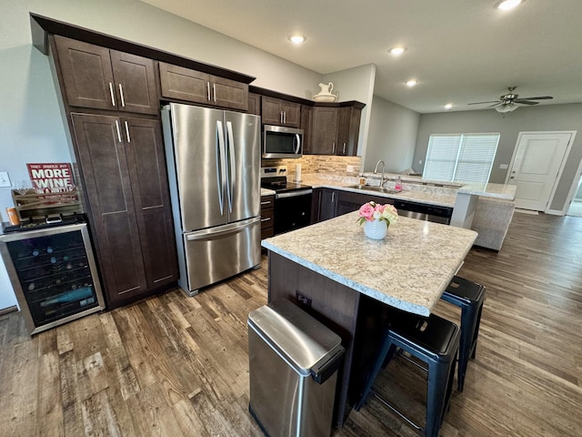 921 S Columbia St, Centralia, MO 65240 - kitchen with stainless steel appliances, a peninsula, dark wood-style floors, dark brown cabinetry, and recessed lighting