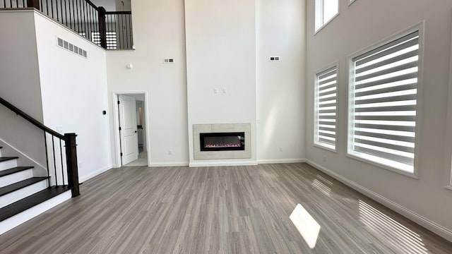 717 Angels Rest Way, Columbia, MO 65203 - unfurnished living room with a high ceiling, wood finished floors, stairs, and a fireplace