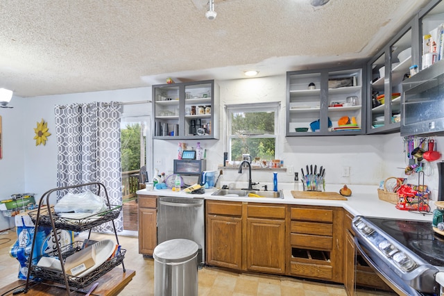 3601 W Hilltop Dr, Columbia, MO 65203 - kitchen featuring stainless steel dishwasher, a textured ceiling, open shelves, plenty of natural light, and light countertops