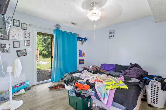 3601 W Hilltop Dr, Columbia, MO 65203 - bedroom with a textured ceiling, access to outside, and wood finished floors