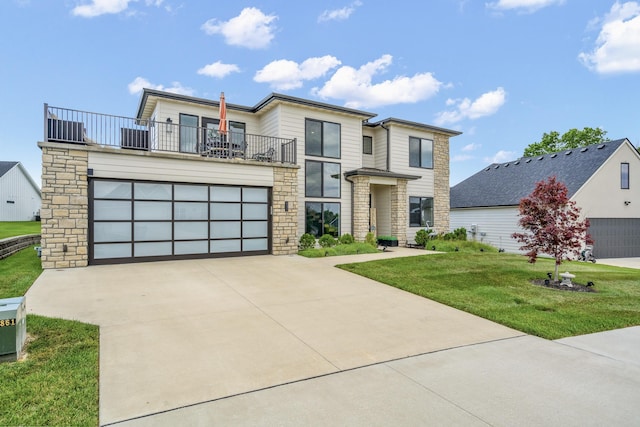 613 Red Feather Ct, Columbia, MO 65203 - contemporary home with stone siding, a balcony, a front lawn, a garage, and concrete driveway