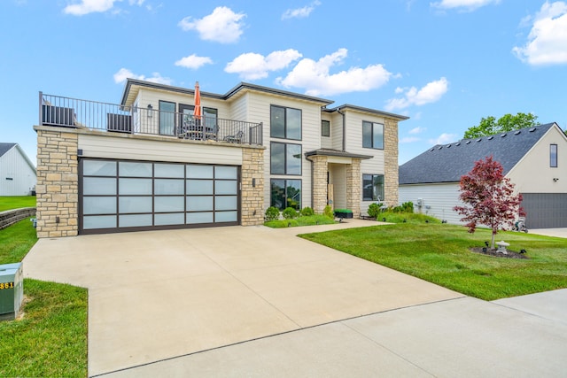 613 Red Feather Ct, Columbia, MO 65203 - modern home with a balcony, stone siding, a front lawn, a garage, and driveway