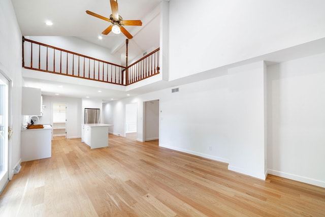 3112 Crestwood Ln, Columbia, MO 65203 - unfurnished living room with high vaulted ceiling, a ceiling fan, and light wood finished floors