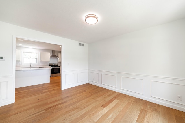 3112 Crestwood Ln, Columbia, MO 65203 - unfurnished room with wainscoting, light wood-type flooring, and a decorative wall