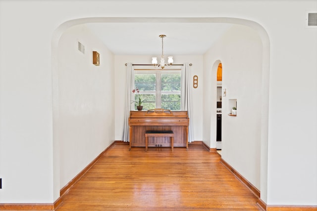 709 Clayton St, Columbia, MO 65203 - hall with arched walkways, light wood-style floors, and a chandelier