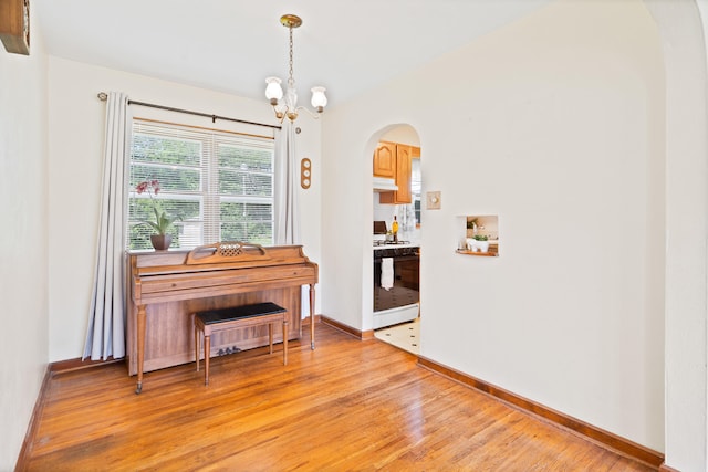 709 Clayton St, Columbia, MO 65203 - dining space with arched walkways, light wood-type flooring, and a chandelier