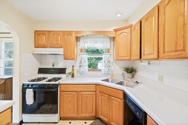 709 Clayton St, Columbia, MO 65203 - kitchen with gas range oven, black dishwasher, under cabinet range hood, light countertops, and arched walkways