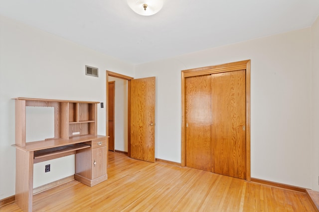 709 Clayton St, Columbia, MO 65203 - unfurnished bedroom with light wood finished floors, a closet, and a desk